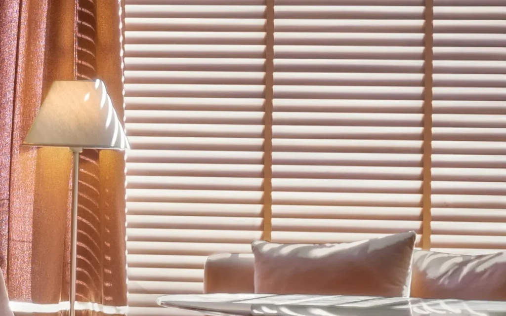 Persianas horizontais Amorim em sala com cortinas leves e luz natural controlada